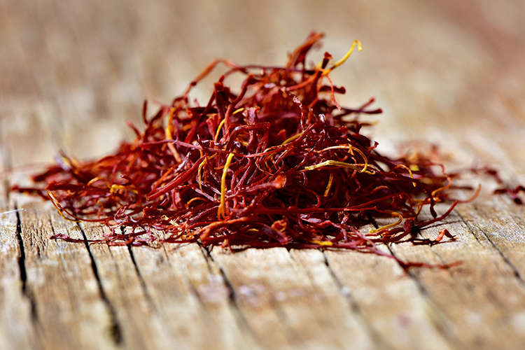 a pile of saffron threads on a rustic wooden table
