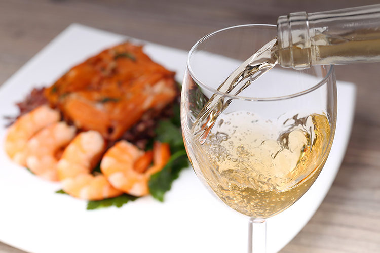 Pouring white wine and seafood background